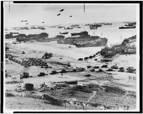Landing craft, barrage balloons, and troops coming ashore at Normandy on D-Day, June 6, 1944. <br />Source: Library of Congress