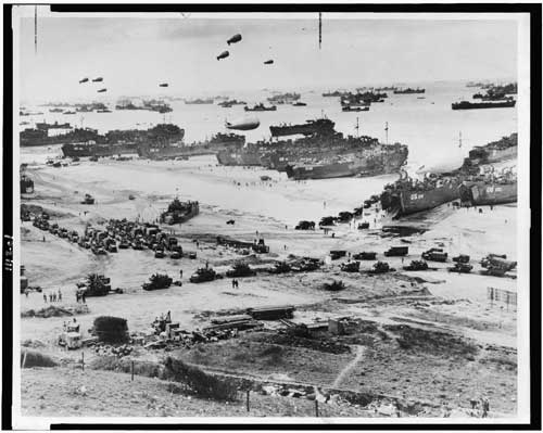 Landing craft, barrage balloons, and troops coming ashore at Normandy on D-Day, June 6, 1944. <br />Source: Library of Congress