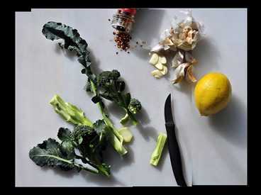 lemon, broccoli, chili flakes, garlic on cutting board with knife
