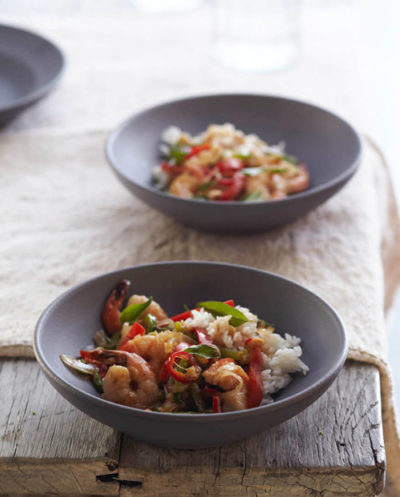 Bowls of stir fried shrimp on a table.