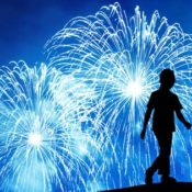 Silhouette of a young girl against a firework-filled sky. Source: Shutterstock.com / © Hofhauser