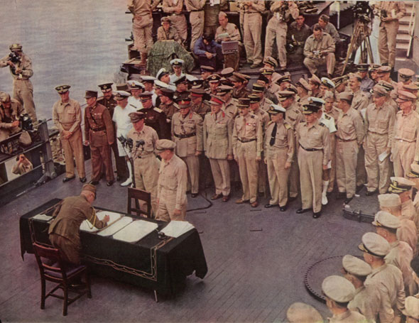 Japanese surrender aboard the battleship Missouri in Tokyo Bay on September 2, 1945. In the foreground, General Yoshijiro Umezu is signing the surrender terms for the Japanese Imperial General Headquarters. On the general’s right, opposite side of table, is Lt. Gen. Richard K. Sutherland, General MacArthur’s Chief of Staff. Back of microphones stands General of the Army Douglas MacArthur. Reading left to right, the first row of men facing the camera in back of General MacArthur are: Admiral of the Fleet Chester W. Nimitz; Gen. Hsu-Yung-chang, China; Adm. Sir Bruce Fraser, Britain; Lt. Gen. Derevyanko, USSR; Gen. Sir Thomas Blarney, Australia; Col. L. Moore Cosgrave, Canada; Gen. “Jacques Leclerc” (Count Philippe de Hauteclocque), France; Vice Adm. Conrad Helfrich. Netherlands; Air Vice Marshal L. M. Isitt, New Zealand. The officer at the extreme right is Gen. Jonathan M. Wainwright. (Photo by Larry Keighley)