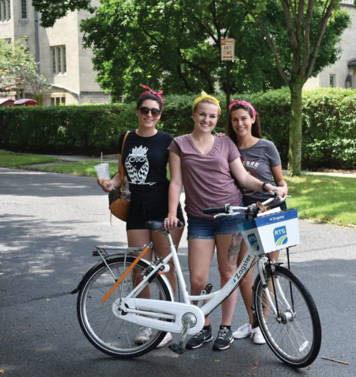 Women bikers pose with a pike in a Rochester neighborhood.