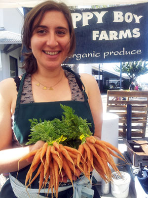 woman holding carrots at farmers market