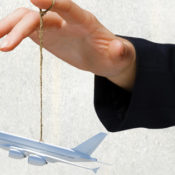 Hand holding toy airplane on a string