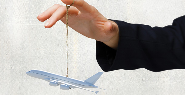 Hand holding toy airplane on a string