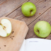 3 apples, cutting board, and cookbook