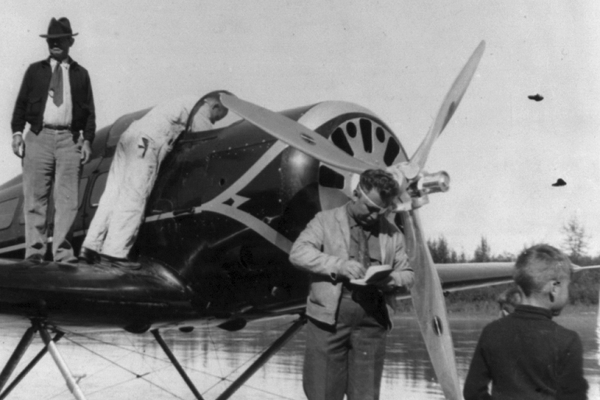 Men stand around an airplane