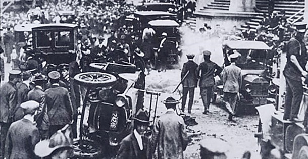 Police and onlookers in the aftermath of a bombing in a busy street.