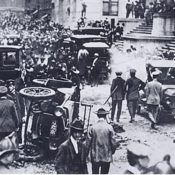 Police and onlookers in the aftermath of a bombing in a busy street.