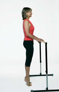 woman holding exercise bar stretching calves