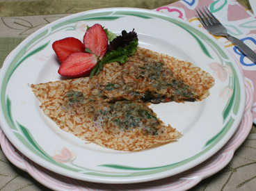 mushroom and spinach chickpea crepe with strawberry garnish
