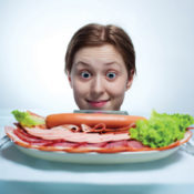 Girl staring at plate of meat