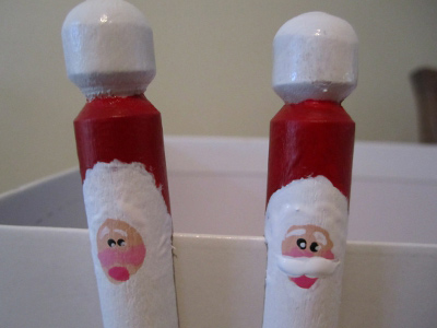 Close-up of Santa faces painted on wooden clothespins hanging on shoebox
