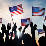 silhouetted people holding American flags
