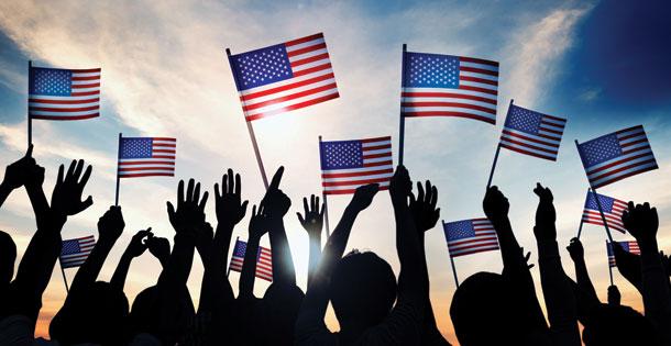 silhouetted people holding American flags