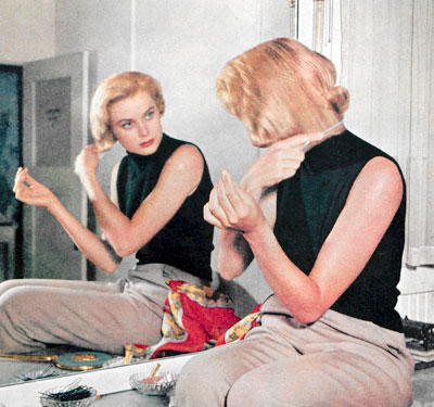 Grace Kelly fixing her hair in the mirror