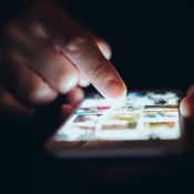 A hand poking at a phone screen