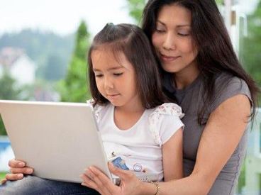 Mom and daughter at laptop. Photo by Tyler Olson via Shutterstock.