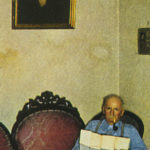 June Rowan sitting beneath portrait of his grandfather.