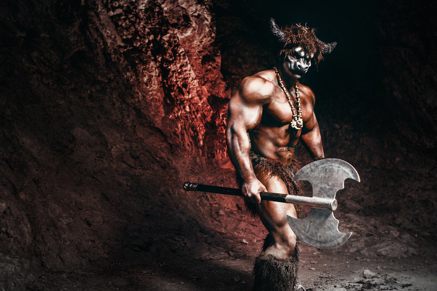 A buff minotaur in a cave wielding a double-bladed axe.