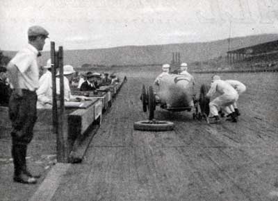 Rigid Rules Prevent More Than Two Pitmen Working on a Car While it Stops for Tire Changes or Supplies. Gas and Oil Have Been Taken on, the Tire Change is Completed and the Car Starts the Minute it is Shoved Off the Jack.