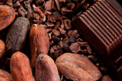 A pile of cocoa beans with a chocolate bar