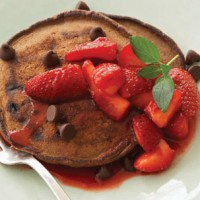 Delicious pancakes with chocolate chips and strawberries.