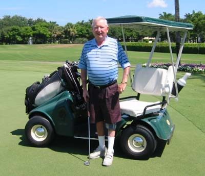 Bill Hefferon standing next to a golf cart.