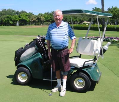 Bill Hefferon standing next to a golf cart.