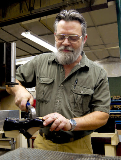 Daniel Barnes demonstrates "lasting," a process ensuring a shoe holds its fit for years.