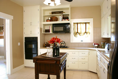 Kitchen after. This opaque stain in Winter White applies like normal paint but is technically a stain. Using a semi-transparent stain allows some of the wood grain to still show, whereas painting hides wood grain.