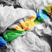 A pile of discarded plastic bags in a grayscale photo. A rainbow color filter is banded over it.