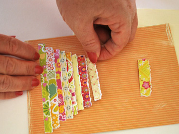 hands gluing strips of paper to card front