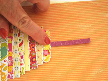 hand gluing paper candle to paper birthday cake