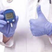 doctor holding glucose monitor with a smiley face on it
