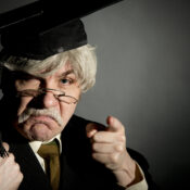 A snooty professor in black robe, mortar board, and pince nez glasses points at you with disdain and disappointment