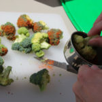 dipping broccoli in spice mixture