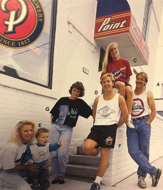 Old photo of young and hip people posing with Stevens Point merchandise.