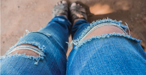 A pair of jeans that are torn at the knees.