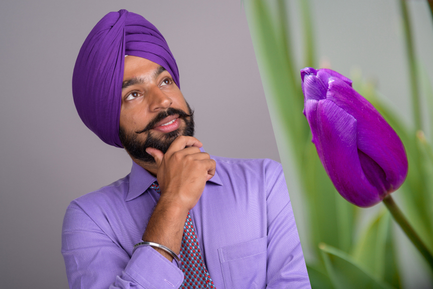 Man wearing a turban and a tulip flower