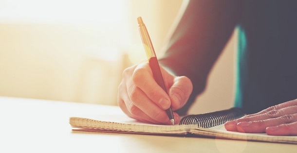 A man writing in a notebook